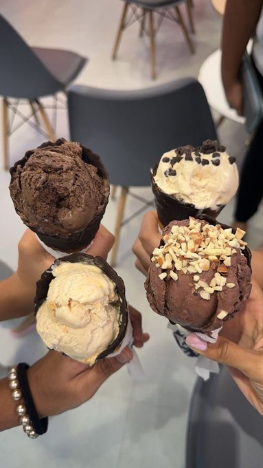 The image shows four ice cream cones, each with a different flavor - chocolate, vanilla, mint, and cookie dough. Three people are holding up their respective ice cream cones for a photo. The caption of the image reads "Good afternoon @UseTria fixes the front door to crypto. No more bouncers asking for seed phrases. @Sleepagotchi fixes the back door to productivity. No more entering the day exhausted. You've done enough today".