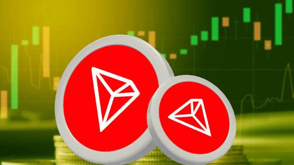 Two red circular tokens displaying white diamond/triangular logos are shown against a green background with stock market candlestick charts.
