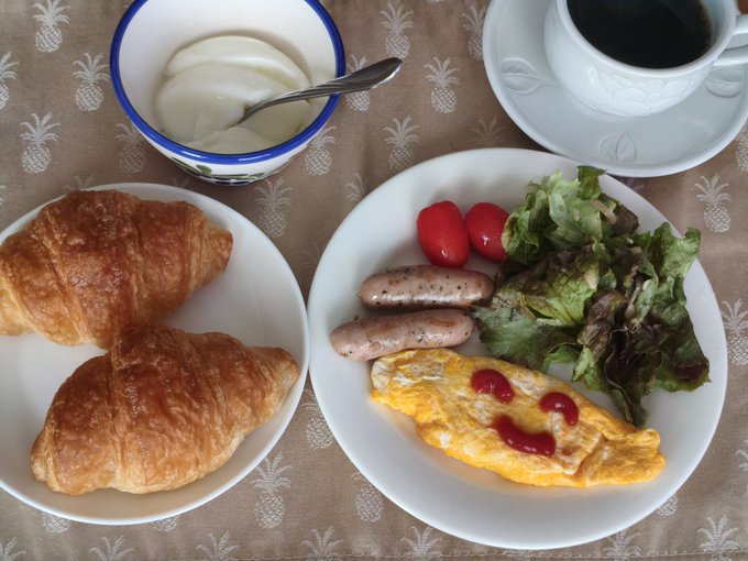 The image shows a breakfast spread with croissants, sausage, eggs, tomatoes, and salad served on plates. The food items are arranged neatly on a dining table, creating an appetizing display for the viewer. The post about Bitcoin seems unrelated to this scene of food presentation but is included as part of the content provided by the platform.