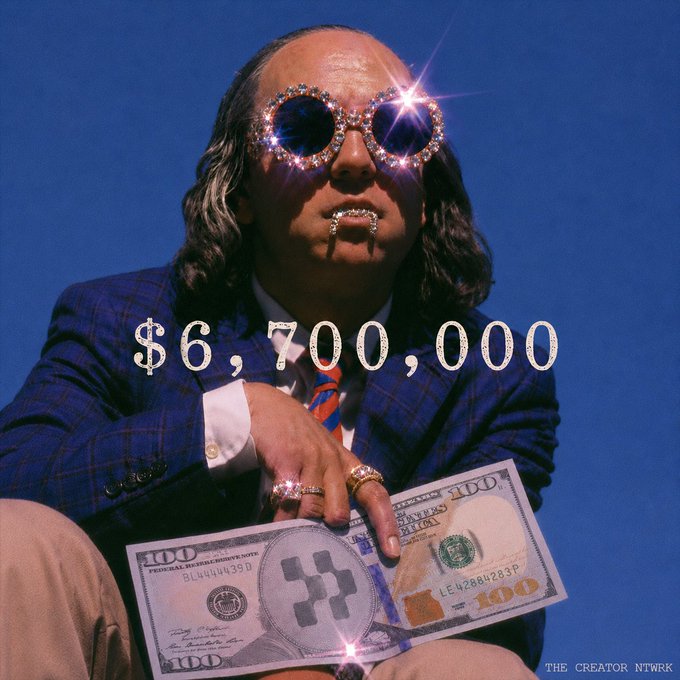 A glamorous portrait of a man in a plaid suit and rhinestone glasses, holding a $100 bill with 'XRP' on it, with the text '$6,700,000' overlaid.