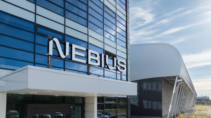 The image shows a modern glass-fronted building prominently displaying the "Nebius" logo on its facade, alongside a curved industrial structure in the background that likely represents one of the company's data center facilities mentioned in the post. The caption connects directly to the announcement, highlighting Nebius's massive $4.5B convertible senior notes offering aimed at expanding its AI infrastructure, including data center construction and GPU procurement, with tokenized $NBIS shares now tradable 24/7 on Solana via Backpack.
