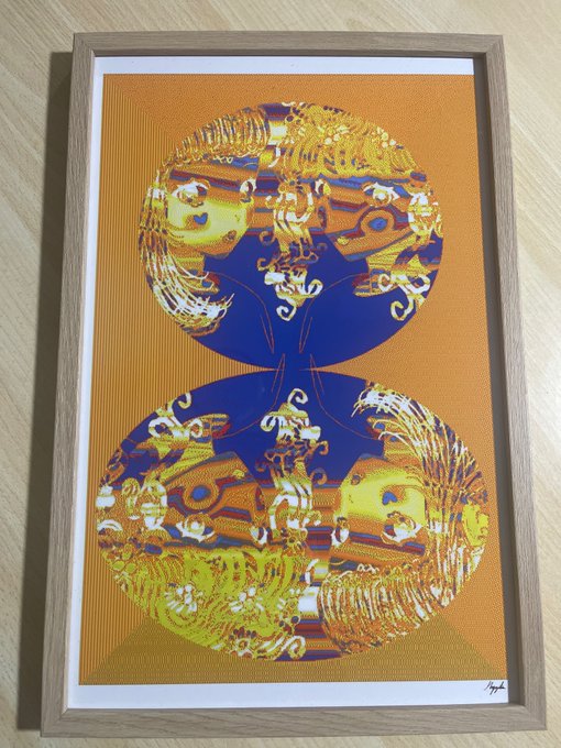 A framed print featuring vibrant orange, blue, and gold abstract art displayed against a wooden surface, showcasing the artist's "INSPIRED: BY US" collection delivered to a collector (@Pennovator) through @verse_works. The piece is signed in the bottom right corner and appears to have a halftone/dotted texture overlay, presented in a light wood frame that complements the warm tones of the artwork.