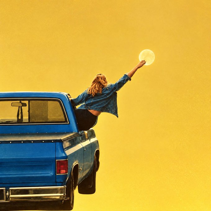 A woman leans out of the back window of a blue pickup truck, reaching up toward a bright moon against a vivid yellow sky, capturing the playful, aspirational spirit of "going to the moon." The image visually echoes the post's excitement about GM's potential moon-bound rally.