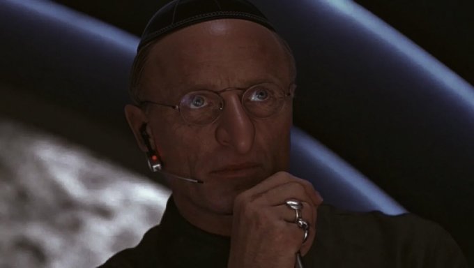 A bald man wearing a kippah, glasses, and a headset displays a skeptical, contemplative expression with his hand resting near his chin, suggesting doubt. The post implies the image conveys a tone of disbelief or concern, as if warning that the $60k level may be a temporary floor rather than a true bottom.