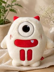 A cute, round, white plush toy with small red devil horns and a single large eye sits against a beige background.