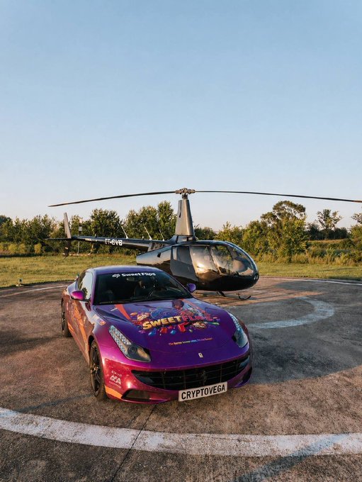 A vibrant pink Ferrari FF branded with "SweetFlips" logos and a "CRYPTOVEGA" license plate is parked on a helipad next to a private helicopter, visually representing the luxury lifestyle promised by the CryptoVega × SweetFlips $150,000+ giveaway promotion.