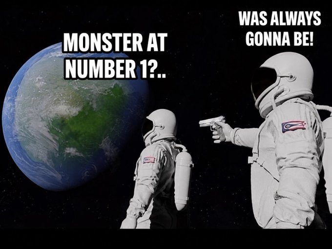A surreal meme image showing two astronauts in space, one pointing a gun at the other, with Earth looming large on the left bearing the text "MONSTER AT NUMBER 1?.." and "WAS ALWAYS GONNA BE!" in the upper right, humorously personifying the rivalry between the $MONSTER token and its competitor referenced in the post.