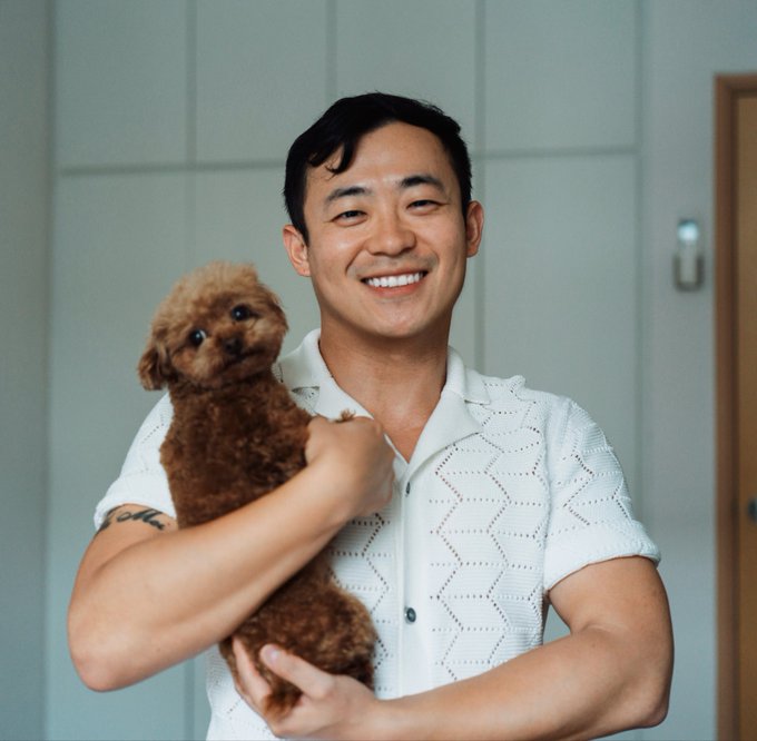 A smiling man in his mid-30s holds a small brown poodle close to his chest in a softly lit indoor setting. The image captures a personal, milestone moment that aligns with the post's reflection on turning 35 and looking back on 14 years of involvement in the Bitcoin community.