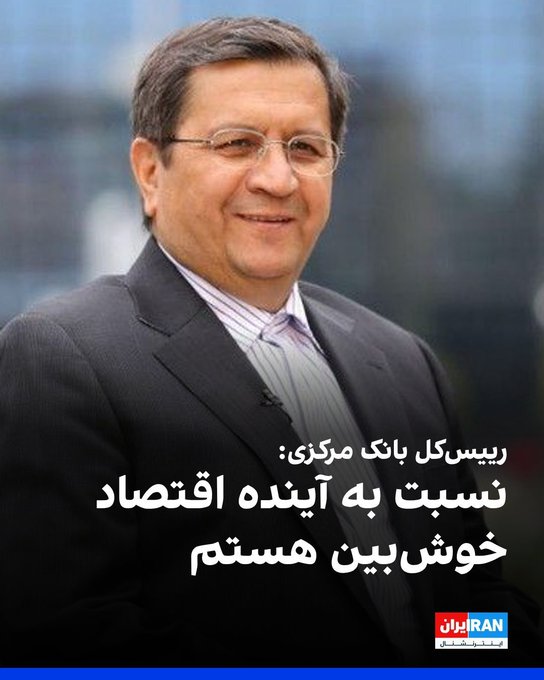 A man in a suit and glasses smiles, with Persian text and an 'IRAN' logo visible at the bottom.
