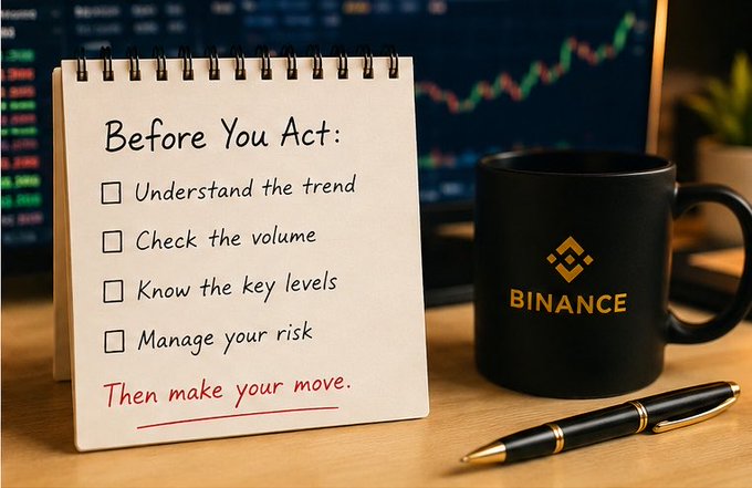 A spiral-bound notepad displays a "Before You Act" checklist (understand the trend, check the volume, know the key levels, manage your risk) with "Then make your move" written in red below, sitting beside a black Binance-branded mug and pen on a desk with a cryptocurrency chart in the background. The image reinforces the post's message about needing context before reacting to crypto market movements, suggesting disciplined preparation over impulsive trading decisions.