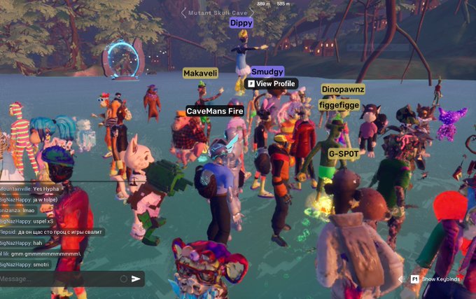 A screenshot from a virtual world game shows a crowd of avatars gathered, with visible usernames including 'Makaveli', 'Smudgy', 'CaveMans Fire', 'Dinopawnz', and 'G-SPOT' floating above their heads.