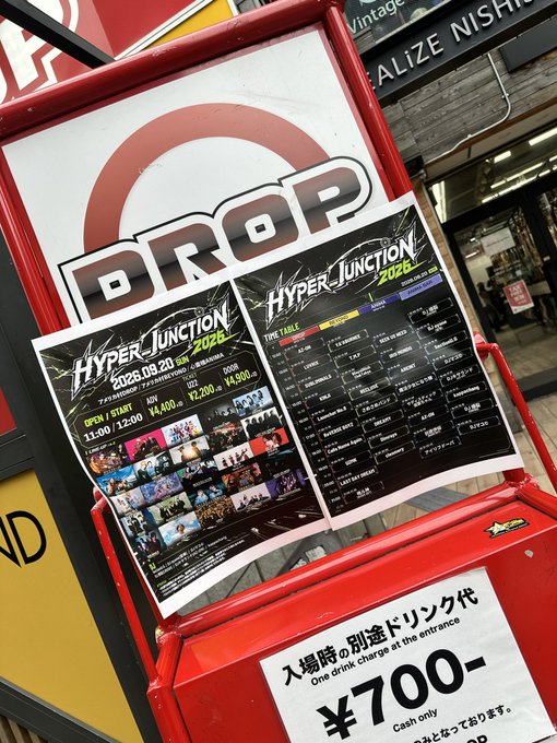 A promotional poster for 'HYPER JUNCTION 2026' event displayed on a red 'DROP' sign at what appears to be a Japanese venue, advertising a September 20, 2026 event from 11:00-12:30 with an entrance drink charge of ¥700.