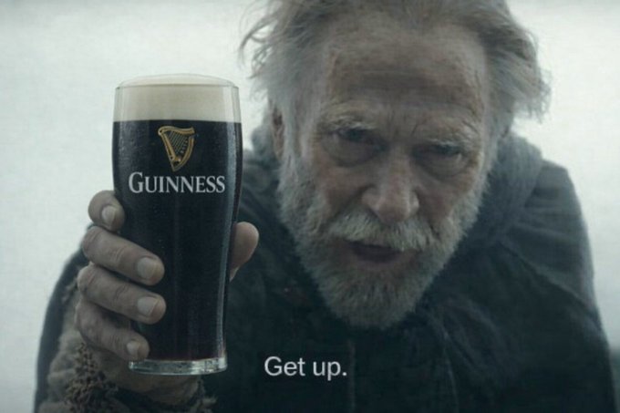 An advertisement image showing a weathered older man with a gray beard holding a pint glass of Guinness stout, with the word 'Guinness' on the glass and the tagline 'Get up.' at the bottom.