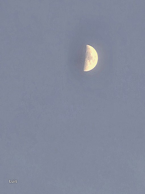 A half moon glowing in a hazy, light blue sky, with the name 'Luis' in the bottom left corner.