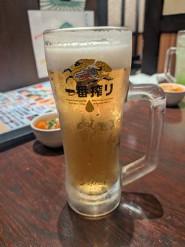 A frothy mug of Kirin Ichiban beer displayed at a Japanese restaurant table with menus in the background.