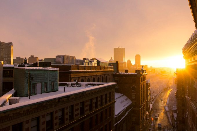 The image shows a city skyline at sunrise or sunset, with buildings of various sizes and designs lining the streets below. The sun's warm glow illuminates the scene, creating a serene atmosphere as the day comes to an end. In the foreground, there is a green building that stands out against the urban backdrop. The post also mentions the release of Quip Network, which has been gaining momentum with one-command deployment and a large number of participants in their testnet. This suggests that the platform is growing rapidly and attracting users who appreciate its simplicity and ease of use.