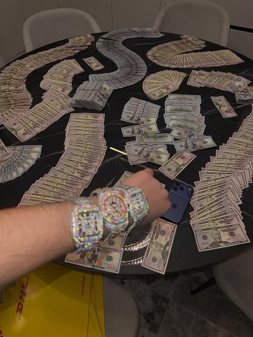 The image shows a person wearing diamond-encrusted wristwatches, with their hand resting on top of a table covered in money. The scene suggests that they might be involved in some sort of financial transaction or are receiving payments for their work. The presence of multiple stacks of money and the watches indicate that this could be related to a business or an individual who is profiting from their services, possibly through online platforms like PayPal.

The post about X payouts implies that there might be a discussion or debate surrounding the payment methods being used in the image. It could also be a reference to a specific case where someone received payments via cryptocurrency or another digital currency, which has become increasingly popular for financial transactions due to its anonymity and ease of use.