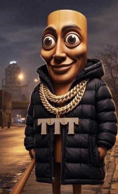 A 3D-rendered character with an elongated head, large eyes, and a wide smile wears a black puffer jacket, gold chain necklaces, and a sparkling 'TTT' pendant, standing on a city street at night.