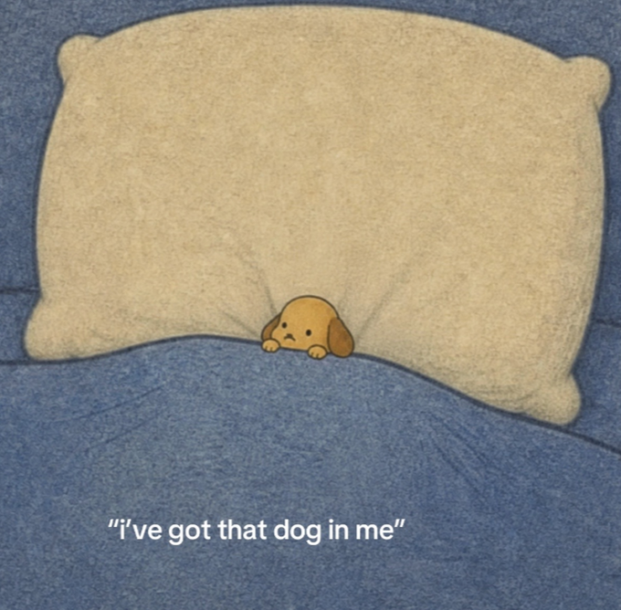 A small cartoon dog peeks out from under a large beige pillow on a blue bed, with the caption "i've got that dog in me" displayed at the bottom — perfectly matching the "$dawg" meme coin's inspiration drawn from a cartoon dog character.