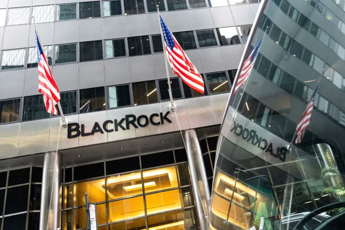 The image shows a large building with three American flags flying from its top. The building appears to be a financial institution or stock exchange, as indicated by the text "BlackRock" written above the entrance. The text also mentions that BlackRock has transferred 1,978 Bitcoins and 14,244 ETH to Coinbase. This implies that the Bitcoin cryptocurrency is being used for transactions at this establishment.