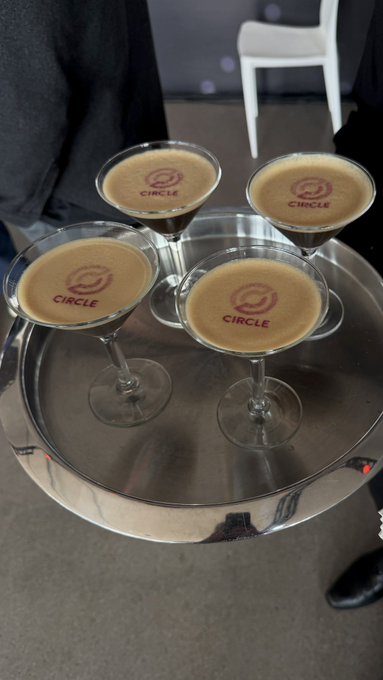 Four martini glasses with espresso cocktails on a silver tray, each featuring a 'CIRCLE' logo branded on the foam.