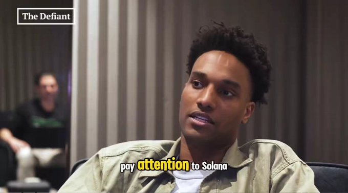 A screenshot from "The Defiant" shows a young man in a beige shirt being interviewed, with the caption "pay attention to Solana" overlaid on the image. The post references Solana alongside the influencers @blknoiz06 and $ANSEM, suggesting the interview subject is likely one of these crypto personalities promoting Solana as a key investment focus.