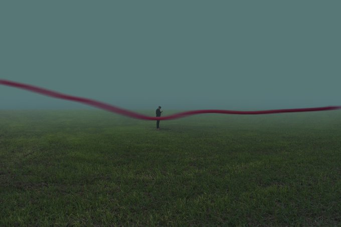 A silhouetted figure stands alone in a vast green field under a teal sky, with a red ribbon-like shape stretching across the scene.