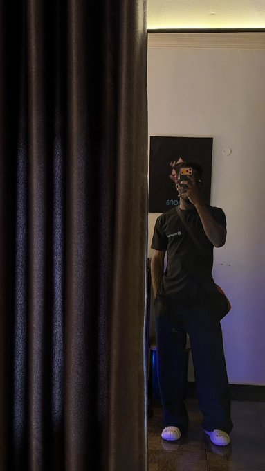 A person takes a mirror selfie at the gym while wearing a black BitgetWallet-branded t-shirt, matching the post's mention of rocking their BitgetWallet merch on leg day.