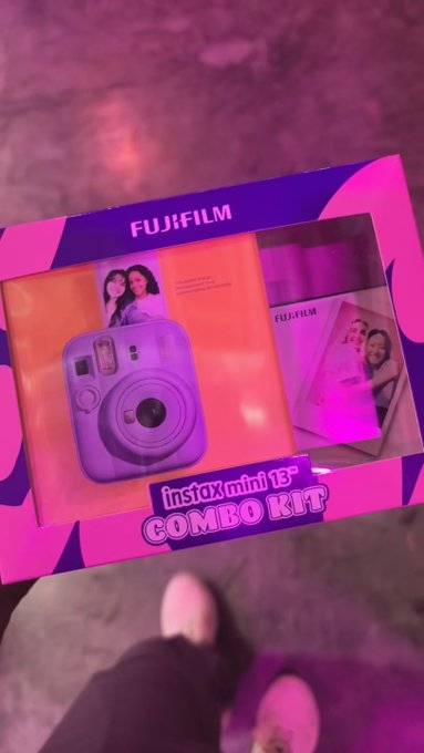A photo of a pink and purple 'FUJIFILM instax mini 13+ COMBO KIT' box, showing the purple instant camera and film packs.