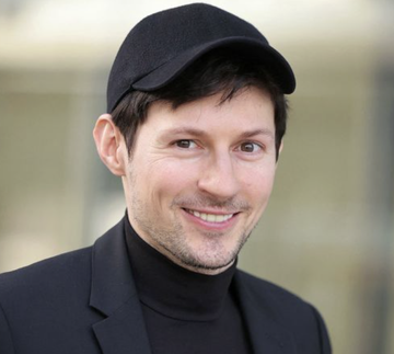 A smiling man wearing a black cap and dark blazer over a black turtleneck, identified in the context as Telegram founder Pavel Durov, who announced the rollout of a native non-custodial $GRAM wallet to over a billion users.