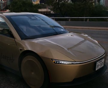 A gold-colored Tesla Cybertruck is parked on a street with a Texas license plate reading 'OF-7635'.