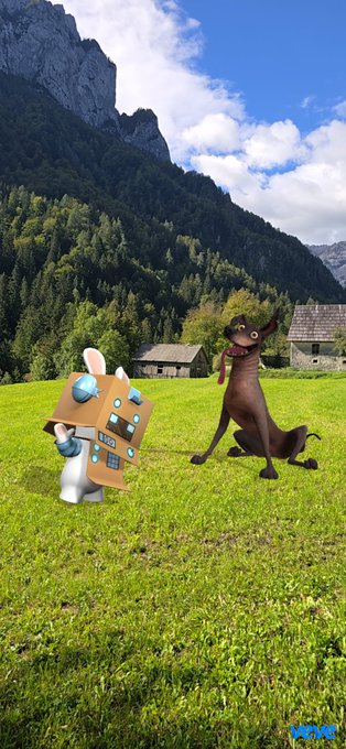 A 3D-rendered scene in a green alpine meadow with mountains and a wooden cabin, featuring a rabbit-like character in a cardboard robot costume and a brown dog-like creature.