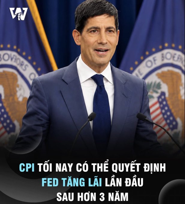 A man in a blue suit speaks at a podium with U.S. government seals in the background, with Vietnamese text reading 'CPI TỐI NAY CÓ THỂ QUYẾT ĐỊNH FED TĂNG LÃI LẦN ĐẦU SAU HƠN 3 NĂM' (Tonight's CPI could determine Fed's first rate hike in over 3 years).