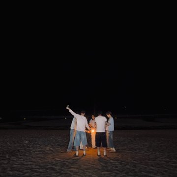 This image shows a group of people gathered around a light source on a beach at night, likely celebrating the "ALD1 DRIVE TO THE TOP" as suggested by the accompanying hashtags and names like #ALPHADRIVEONE, #ALD1, and #XINLONG.