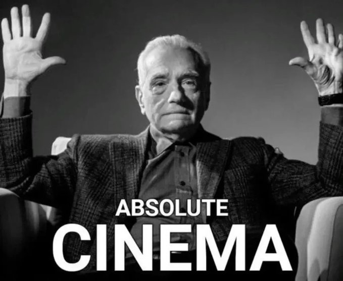 The image features a man sitting in a chair with his arms raised up in the air. The caption below the photo reads "Absolute Cinema", which suggests that this scene might be related to or inspired by a movie title, theme, or concept.