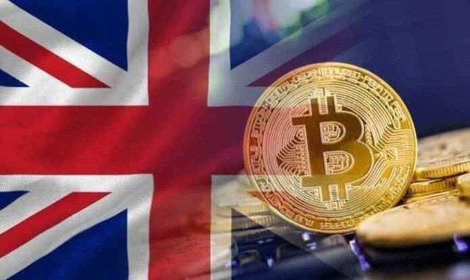 A photograph of a physical Bitcoin coin placed against a UK Union Jack flag background, symbolizing cryptocurrency in Britain.