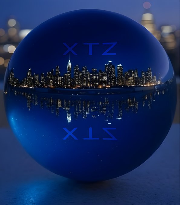 The image features a blue ball with the text "XTZ" written on it, which appears to be a reflection of a city skyline. The city lights are visible through the ball's surface, creating an interesting visual effect. The background of the image is blurred and out of focus, drawing attention to the ball and its reflection in the water below.