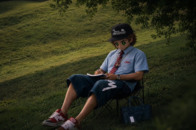 A digital illustration of a person with green eyes wearing a black cap, light blue striped shirt, red tie, and denim shorts, sitting on a folding chair in a grassy field writing in a notebook.