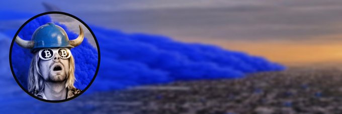A circular avatar featuring a figure wearing a Viking horned helmet and sunglasses with Bitcoin (₿) symbols on the lenses is overlaid on a blue, cloud-like landscape with a sunset in the background. The image serves as a custom banner for the Base token $COBIE, as noted in the accompanying post.