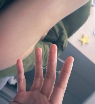 A hand holds up thin, stringy strands of sticky residue stretched between the fingers, suggesting someone has just peeled off dried glue or tacky material. The post's caption "Mining. see?" humorously compares the tedious task of removing the stubborn residue to the labor-intensive process of cryptocurrency mining, while the hashtags #女大 (female university student) and #大一 (freshman year) suggest the poster is a college freshman sharing this relatable daily annoyance.