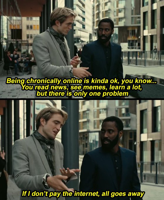 Two men in suits (one blond, one Black) having a conversation on a city street with humorous subtitles about being chronically online and paying for the internet.