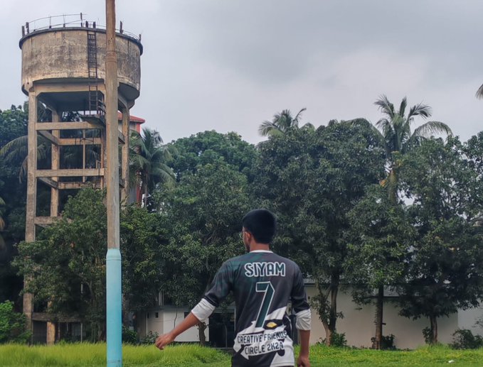 The image features a man wearing a black and white shirt with the number 7 on it standing in front of an old water tower. The man appears to be looking up at the tower, possibly admiring its architecture or contemplating something. In the background, there is a palm tree, adding a tropical feel to the scene. The post about the smart wallet and Web3 platform is related to this image because it highlights how technology can be integrated into various aspects of our lives, including the appreciation of historical landmarks like water towers.