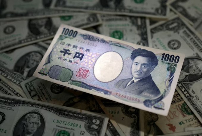A Japanese 1000 yen banknote featuring the portrait of Hideyo Noguchi rests on top of a pile of United States dollar bills.