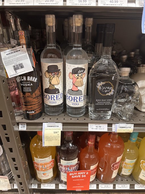 A store shelf displaying various alcoholic beverages including Dutch Barn Vodka, Bored Vodka with giraffe and monkey illustrations, Dano's Hot Vodka, and several flavors of Deep Eddy's Vodka with promotional price tags.