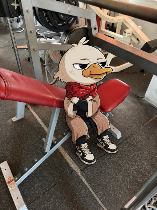 The image features a cartoon duck sitting on an exercise machine with its head resting on the barbell while wearing a red scarf around its neck. The text of the post reads "gQuack, just had a 3 hour chest and shoulders workout + 30 minutes cardio. All this time I kept thinking how awesome it is that I held my Quack Head and never stopped believing in @wallchain even though at some moments I was close to that, albeit."