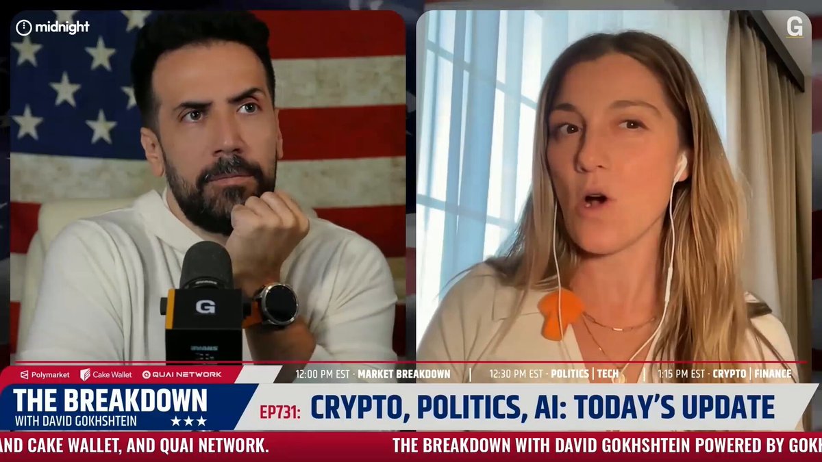 The image shows a man wearing a white shirt with a beard holding a microphone while another woman with earbuds is also present, possibly participating in an interview or discussion related to cryptocurrency and mobile wallet security. The focus of the image is on the conversation between these two individuals, which highlights the importance of staying informed about the latest developments in the world of crypto and mobile wallets.