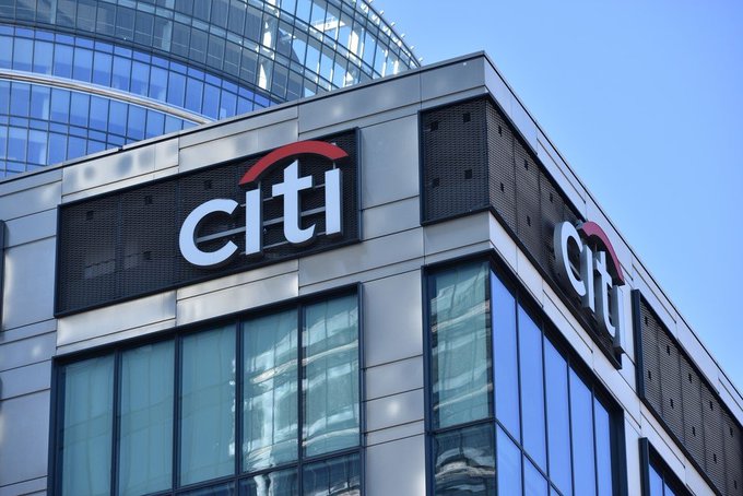 An exterior view of a modern glass building featuring the 'Citi' logo prominently on two adjacent sides.