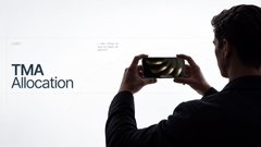 A minimalist image showing 'TMA Allocation' text on the left and a man using a smartphone on the right side.