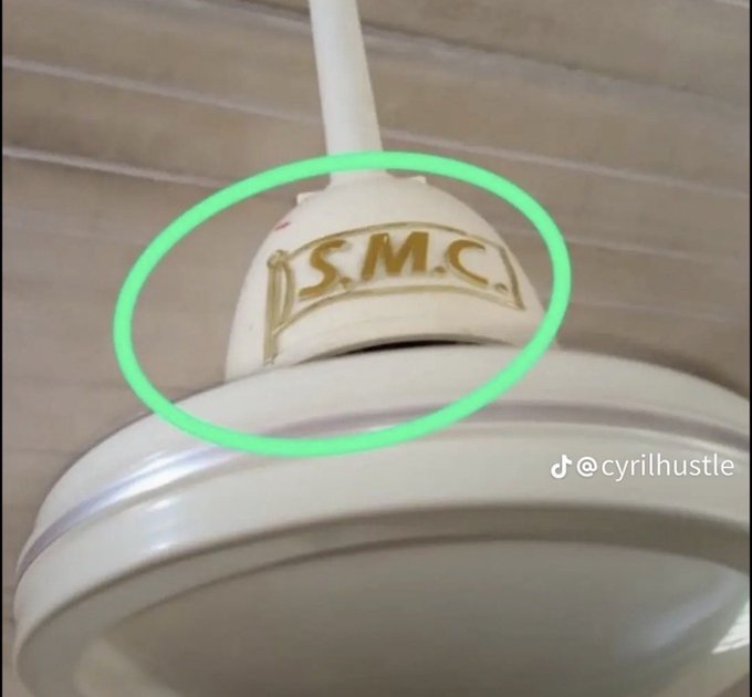 A close-up of a white ceiling fan light fixture with 'S.M.C.' embossed on it, circled in green, with the TikTok handle @cyrilhustle visible.