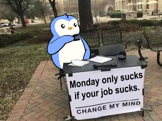 A penguin character sits at an outdoor table with a sign reading 'Monday only sucks if your job sucks. CHANGE MY MIND'.